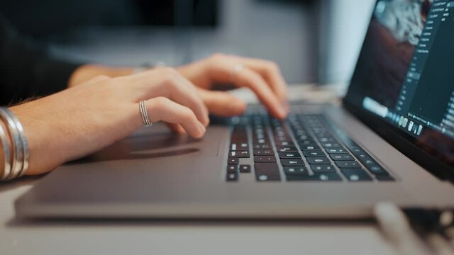 Timelapse shot of a man typing on a notebook pc, view from side. Shallow focus