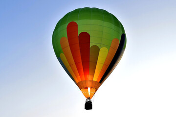 Fahrender Heißluftballon im Licht der aufgehenden Sonne am frühen Morgen in Großaufnahme