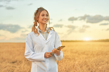 Woman farmer white coat smart farming standing farmland smiling using digital tablet Female...