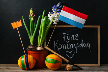 Koningsdag or King's Day is a national holiday in the Kingdom of the Netherlands. Painted oranges and the flag of the Netherlands on a chalkboard background