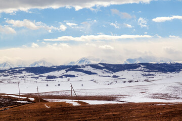 Fototapeta na wymiar Caucasus Mountains, Panoramic view of the mountains on the horizon in winter day. On the way from Arkhyz to Dombay. Western Caucasus, Karachai-Cherkess, Russia. Serpentine road
