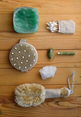 Body skin care. Natural bristle brushes, sea salt, body scrub, natural stone roller, brush on wooden background