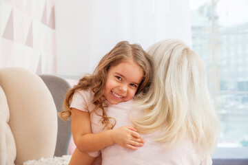 Little girls of Caucasian appearance tenderly hugs her mother