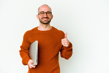 Young bald man holding a laptop isolated on white background smiling and raising thumb up