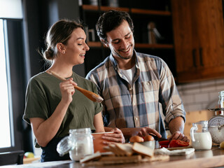 Husband and wife in kitchen. Young couple preparing delicious food at home.