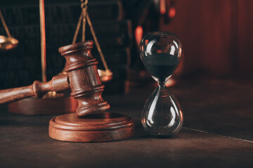 Obraz na płótnie Canvas Hourglass and wooden judge gavel on table close-up.