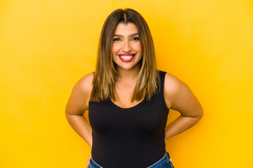 Young indian woman isolated on yellow background happy, smiling and cheerful.