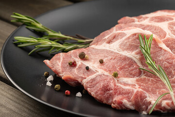 Raw meat. Slice of fresh raw meat with rosemary. Preparing meat for a barbecue. Healthy, natural food.