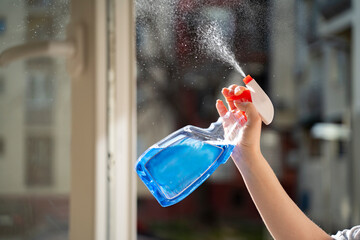 Spring is time for big cleaning , woman spraying dirty window closeup 