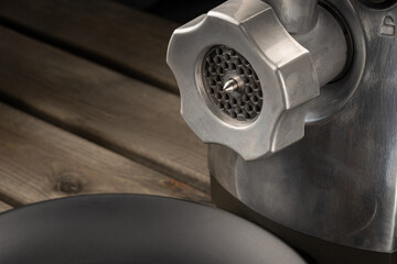 Electric meat mincer on a wooden background. Close-up.