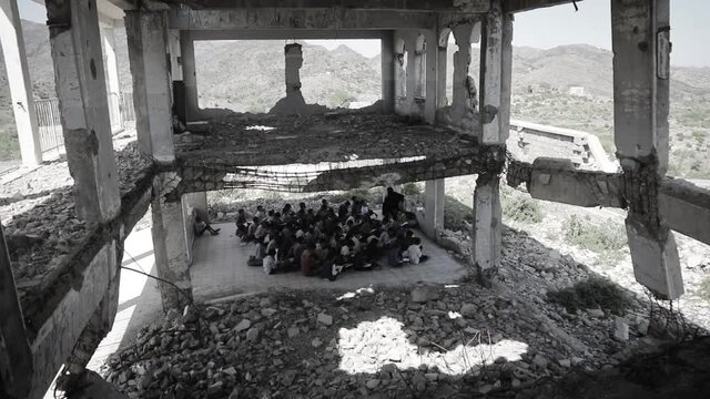 Yemeni children study inside a school destroyed by the war in Taiz City , Yemen