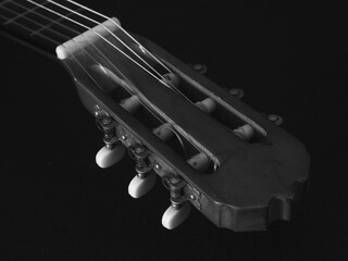 Nahaufnahme eines Gitarrenkopfes mit Wirbel und Sattel in schwarz und weiß Fotografie - Powered by Adobe
