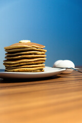 Freshly made hot pancakes accompanied by butter