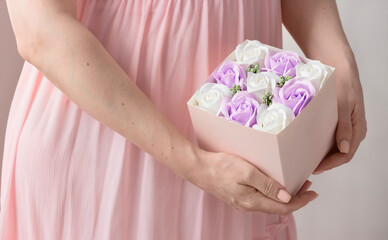Feminine hands holding bouquet roses above pink dress. Spring flowers set
