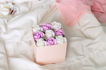 Fototapeta na wymiar White and violet roses in pink mockup box.