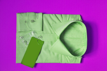 pre-sale preparation on textile fabric. New fabric packed men's light green shirt on a violet background. Shirt packed for sale. Isolated shirt. Concept wear for bussiness