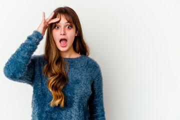 Young caucasian cute woman isolated on white background shouts loud, keeps eyes opened and hands tense.