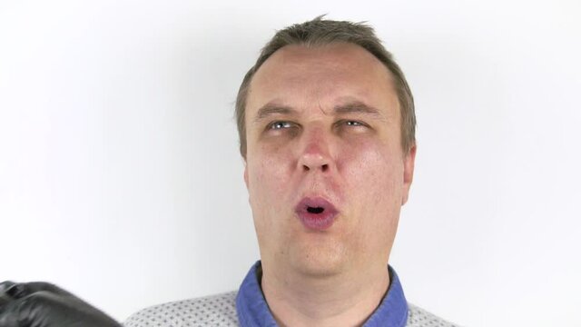 The fishtail hits the man in the face. A portrait of a man who was hit in the face by a fish. He grimaces into the camera. Slow motion. Close-up.
