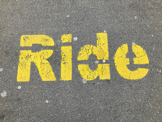 Yellow Ride inscription painted on asphalt