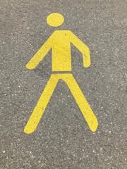 Yellow painted pedestrian sign on asphalt in Switzerland