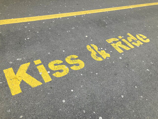 Yellow Kiss and Ride inscription painted on asphalt
