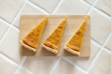 Top view homemade pumpkin pie on a wooden board, background.