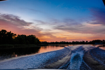 Deep river. Evening. Moving from coast to coast. A very beautiful path through the water behind the...
