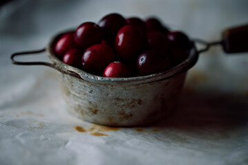 Fresh cranberries in vintage tea strainer. Selective focus on cranberries. Close up.