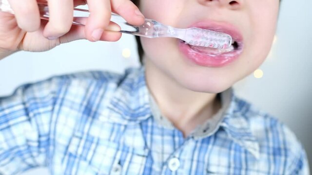 child, kid 6-7 years old diligently brushes teeth and colored children's paste, dental concept, oral hygiene, daily morning routine