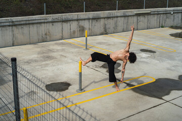 Chico bailando en parking y frente pared roja