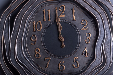 warped shape retro style clock showing one minute to midnight .