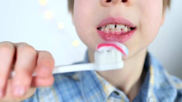 child, kid 6-7 years old diligently brushes teeth and colored children's paste, dental concept, oral hygiene, daily morning routine