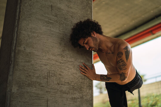 Chico bailando en parking y frente pared roja