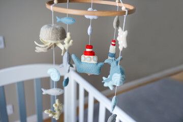 Diy craft baby crib mobile. Toys hang over the crib