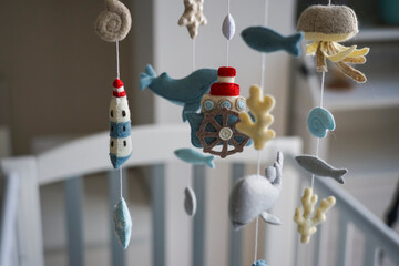 Diy craft baby crib mobile. Toys hang over the crib
