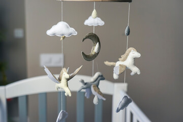 Diy craft baby crib mobile. Toys hang over the crib
