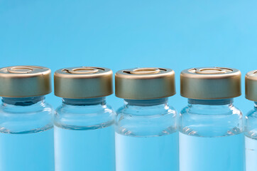 Vaccination campaign, flu immunization shot and medical treatment concept with close up on vaccine vials lined up on blue background with copy space