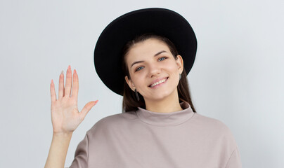 Friendly good-looking european woman joyfully welcome you, wave palm gladly invite greet person, smiling broadly, enthusiastic grin, say hi hello, stand white background