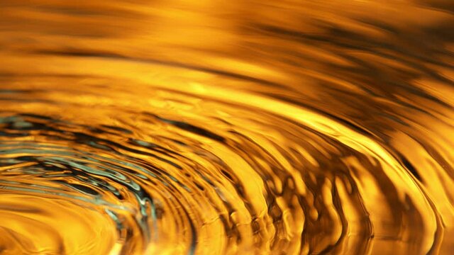 Super Slow Motion Shot of Pouring Liquid on Golden Luxury Background at 1000 fps.