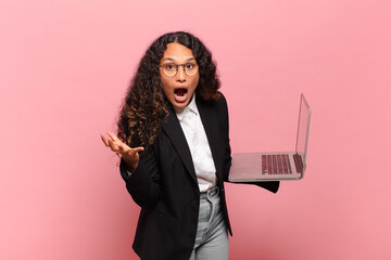 young hispanic woman looking angry, annoyed and frustrated screaming wtf or what’s wrong with...