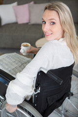happy woman in wheelchair drinking coffee