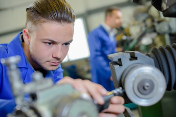 young engineer is using lathe - obrazy, fototapety, plakaty