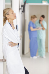portrait of senior female doctor on hospital corridor relaxing