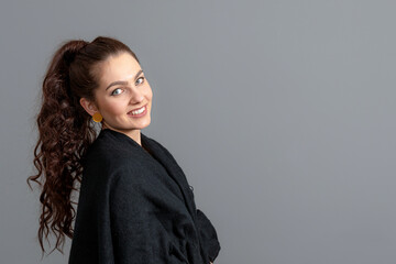 Obraz premium portrait of charming curly-haired woman in a black cloak isolated on a gray background