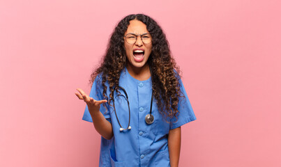 young hispanic woman looking angry, annoyed and frustrated screaming wtf or what’s wrong with...
