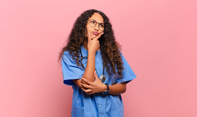 young hispanic woman thinking, feeling doubtful and confused, with different options, wondering...