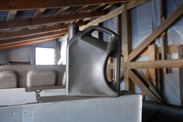 gray plastic canister with engine oil in the garage. do-it-yourself repair and maintenance of equipment.