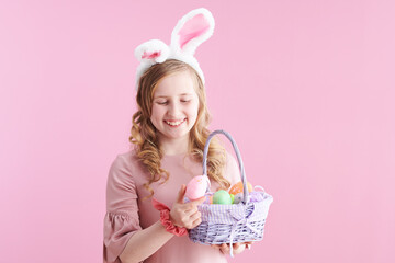 happy stylish child with long wavy blond hair on pink