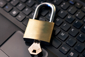 Detail of a metallic security padlock above a computer keyboard,