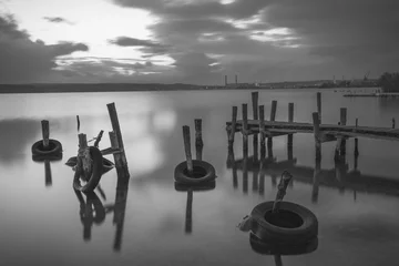 Photo sur Plexiglas Noir et blanc Petit quai et bateau de pêche au village de pêcheurs, longue exposition noir et blanc